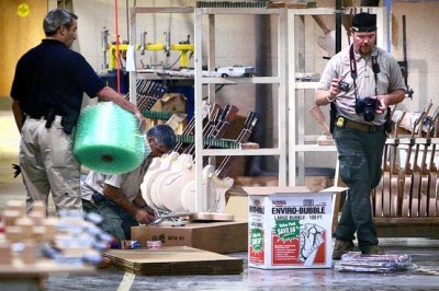 Agents from the U.S. Fish and Wildlife Service pore through the workshop at the Gibson Guitar factory on Wednesday morning.